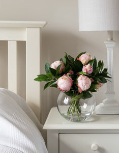 Silk flower arrangements, with pink peonies in glass vase