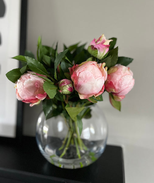 Artificial flower arrangement in vase, faux pink peony flowers. 